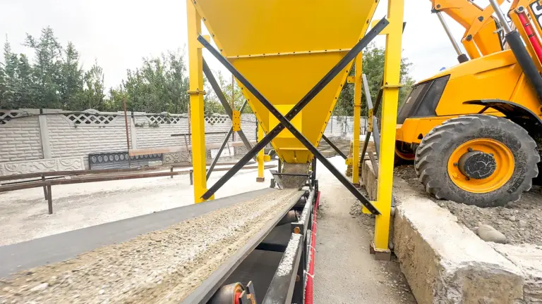Material moving from the aggregate hopper onto the conveyor at the Samtredia customer site